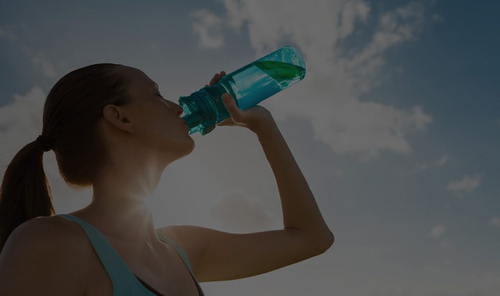 A background image for NEWater of a woman drinking water in the sun